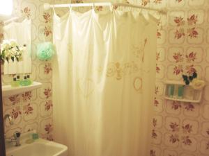 a bathroom with a shower curtain and a sink at Hotel Florakis in Livanates