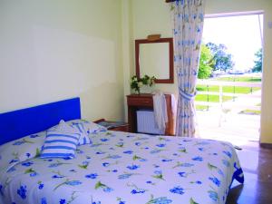 a bedroom with a bed and a mirror and a window at Hotel Florakis in Livanates