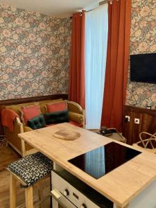 uma cozinha com um balcão, uma mesa e cadeiras em Une maison de famille em Oloron-Sainte-Marie