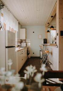 a kitchen with a refrigerator and a table and chairs at Domowe Pielesze in Olszanica