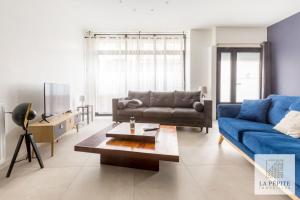 sala de estar con sofá azul y mesa en Atelier 46 - Appartement 2 chambres., en Valenciennes