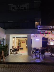 grupa stołów i krzeseł na patio w nocy w obiekcie SP.Place Hotel Koh Chang w mieście Ko Chang