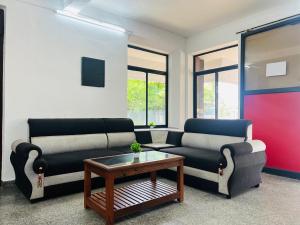 a living room with two couches and a coffee table at Hotel Sunday - Townhouse Club Airport Trivandrum in Trivandrum