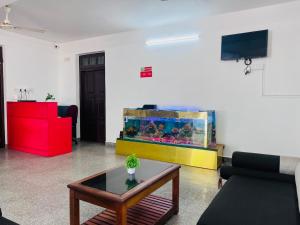 a living room with a large fish tank and a table at Hotel Sunday - Townhouse Club Airport Trivandrum in Trivandrum