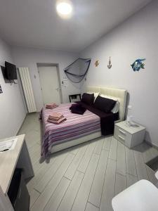 una camera da letto con un grande letto con lenzuola viola e un tavolo di b&b La Rosa dei venti ad Alassio