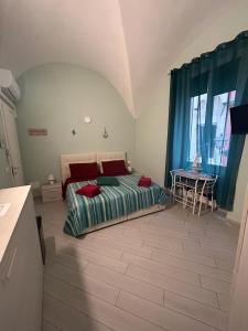 Un dormitorio con una cama y una mesa. en b&b La Rosa dei venti en Alassio