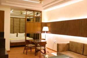 um quarto de hotel com uma cama, uma mesa e cadeiras em Karon Hotels - Lajpat Nagar em Nova Deli