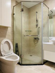 a bathroom with a shower with a toilet and a sink at Vinhomes Landmark 81 in Ho Chi Minh City