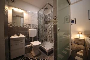 e bagno con servizi igienici, doccia e lavandino. di Nik rooms a Genova