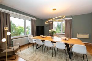 comedor con mesa de madera y sillas blancas en La VILLA du Reims en Colmar