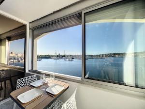 a dining room with a view of the water at Studio Prestige, île des pêcheurs, vue port in Cap d'Agde