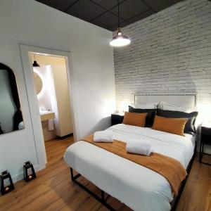 - un grand lit dans une chambre dotée d'un mur en briques dans l'établissement RESIDENCIAL ALCOY Apartahotel, à Alcoy