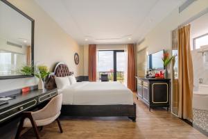 a bedroom with a bed and a television and a tub at Athenia Hoi An Boutique Hotel & Spa in Hoi An +37 photos