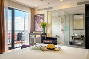 a hotel room with a bed with a hat on it at Athenia Hoi An Boutique Hotel & Spa in Hoi An