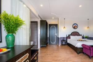 a bedroom with a bed and a vase on a table at Athenia Hoi An Boutique Hotel & Spa in Hoi An