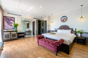 a large bedroom with a large bed and a couch at Athenia Hoi An Boutique Hotel & Spa in Hoi An