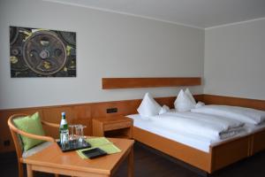a hotel room with two beds and a table with a bottle of beer at Aparthotel Sprendlingen in Sprendlingen