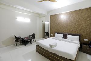 a bedroom with a bed and a table and chairs at Kashi Stay in Varanasi