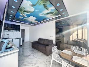 a living room with a ceiling with a palm tree mural at Studio Prestige, île des pêcheurs, vue port in Cap d'Agde