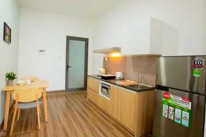 uma cozinha com um balcão, uma mesa e um frigorífico em MNM apartment em Da Nang