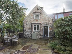 a stone house with a table and chairs in front of it at 5 The Crescent in Caernarfon
