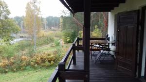 porche de una casa con mesa y vistas en EKOLANDIA domek w lesie na wyłączność, en Tuszkowy