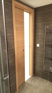 La salle de bains est pourvue d'une porte en bois et d'une douche à l'italienne. dans l'établissement Ravissant studio au coeur du Vieil Antibes, à Antibes