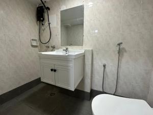 a bathroom with a white sink and a mirror at SS Grey Hotel in Kuala Lumpur