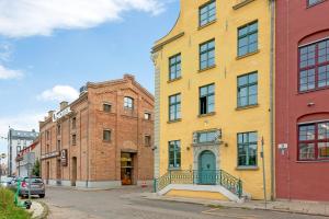 a yellow building on the side of a street at Historical Townhouse by Blue Mandarin in Gdańsk