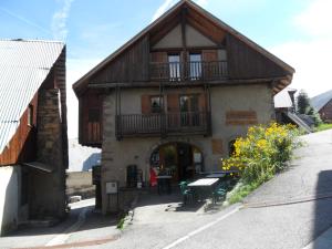 a building with a balcony and a table in front of it at Gîtes Vallouise Ecrins in Vallouise