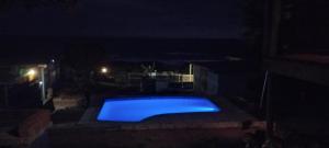 a swimming pool at night with a blue light at Blue Space Beach Shack in Hibberdene