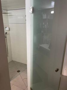 een douche met een glazen deur in de badkamer bij Dream Studio in Herzelia 