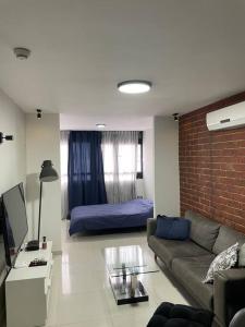 een woonkamer met een bank en een bed bij Dream Studio in Herzelia 