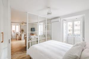 a white bedroom with a white bed and a table at BEAUTIFUL APARTMENT IN THE HEART OF MADRID in Madrid