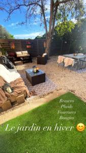 a backyard with a table and a bench and grass at Le mas du bosc in Mauguio