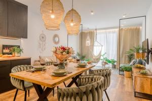 uma cozinha e sala de jantar com uma mesa de madeira e cadeiras em Lumina lux apartment on Drewnowska em Lódź