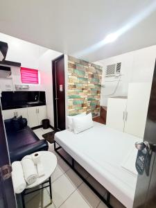 Cette petite chambre comprend deux lits et une table. dans l'établissement Dasma Lofts Hotel near Dela Salle Dasma, à Dasmariñas