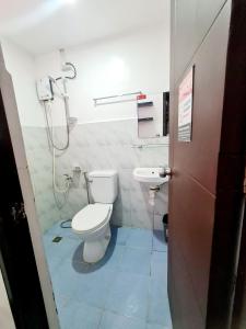 La salle de bains est pourvue de toilettes et d'un lavabo. dans l'établissement Dasma Lofts Hotel near Dela Salle Dasma, à Dasmariñas