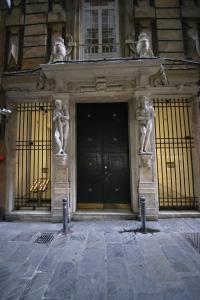 Un edificio con una porta con due statue sopra. di Nik rooms a Genova