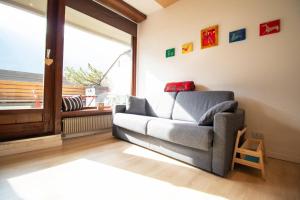 uma sala de estar com um sofá e uma janela em Casa Franz em Campestrin