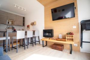 sala de estar con mesa y TV en la pared en Casa Franz, en Campestrin