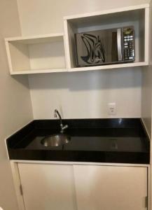 a kitchen with a sink and a microwave at S4 HOTEL Aguas Claras TorresReis in Brasília