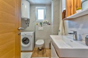 Un pequeño baño con lavadora y lavabo. en Apartman Milosavljević, en Zlatibor 41 fotos más