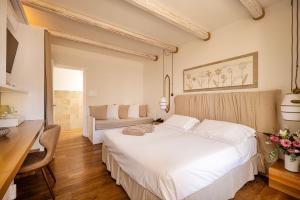 a bedroom with a white bed and a desk at Masseria Bandino & Spa in Otranto +152 photos