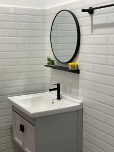 ein weißes Badezimmer mit einem Waschbecken und einem Spiegel in der Unterkunft Lala Homestay 1 in Kuala Terengganu