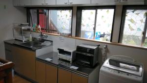 a kitchen with a counter with a microwave and a window at Kōnotori no sato no yado - Vacation STAY 11102 in Kōnosu