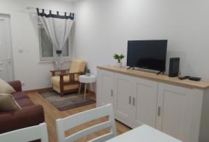 sala de estar con TV de pantalla plana en la barra en Mondalva Apartamentos, en São Pedro de Alva