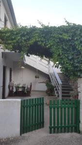 Deux clôtures vertes en face d'une maison avec des escaliers dans l'établissement Apartment Nera, à Sali