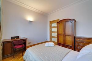 1 dormitorio con 1 cama, vestidor y escritorio en Arena Park Apartment, en Kaunas