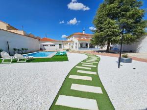 um jardim com um caminho que leva a uma casa em La casa del árbol em Fuentidueña de Tajo